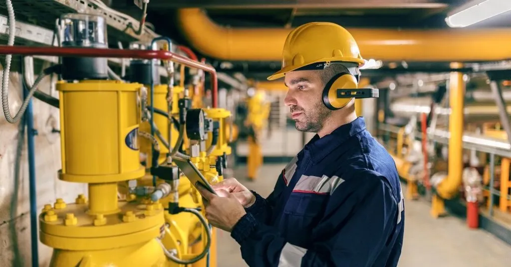 Inspector using a tablet in a hazardous area facility